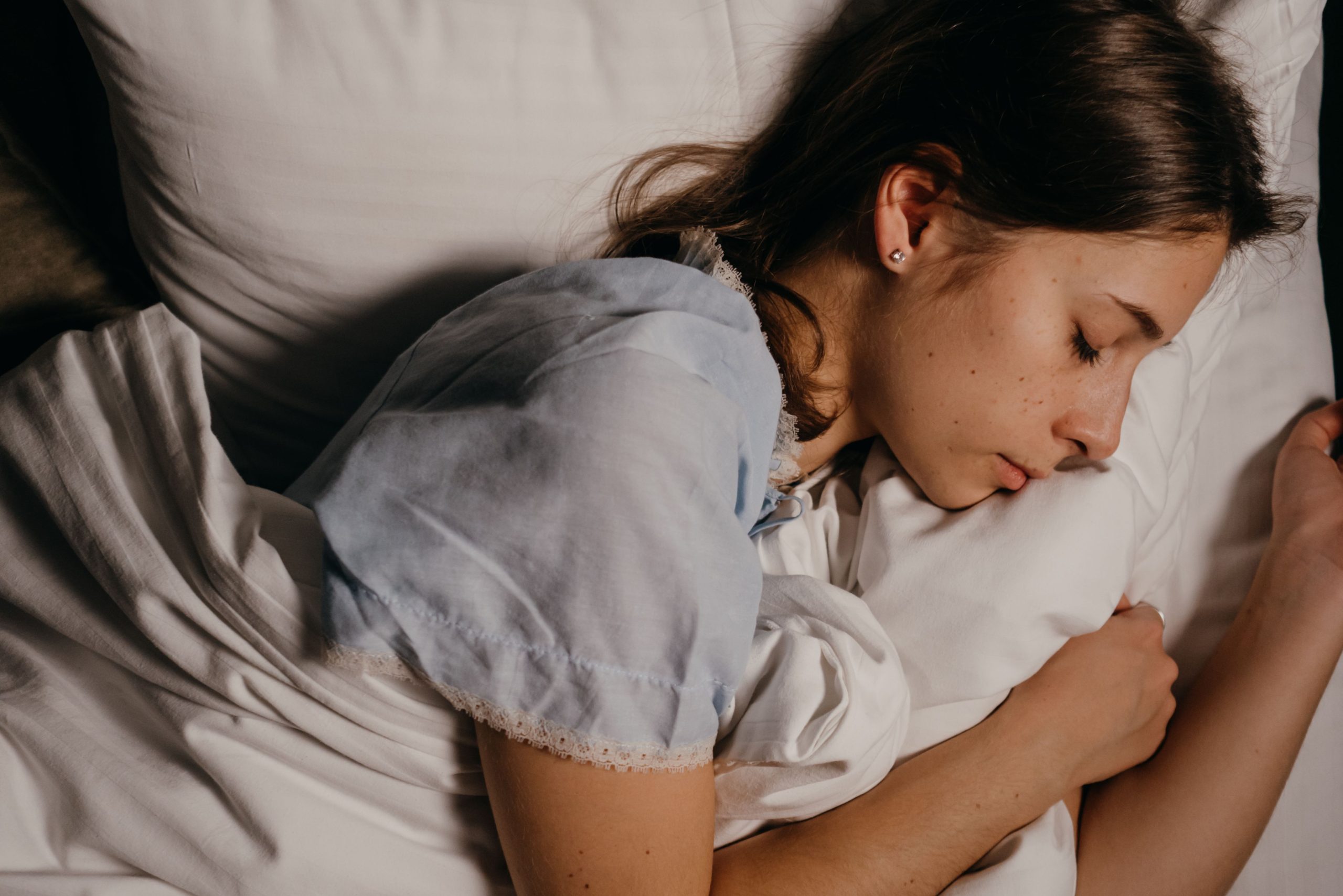 Jeune femme dormant sereinement sur un oreiller blanc