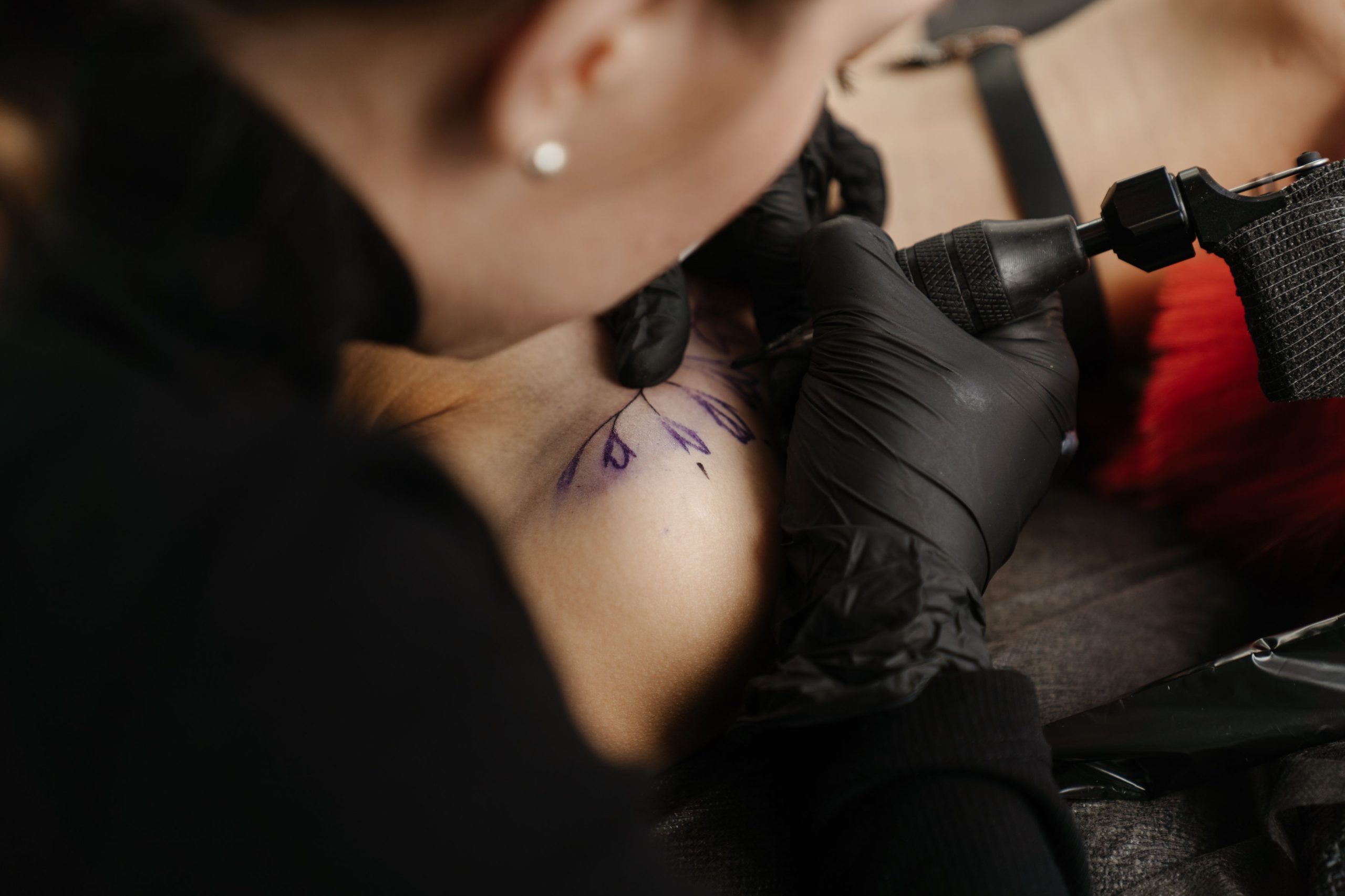 Tatoueur à l'œuvre sur le bras d'un client