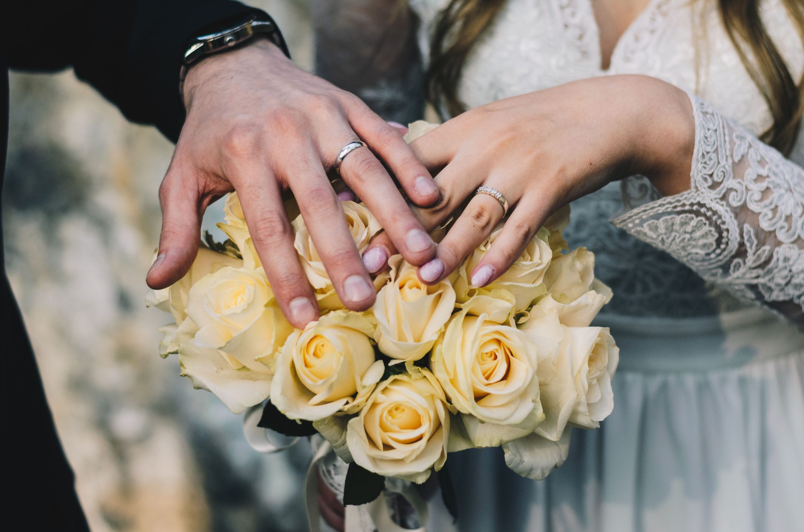 Mains couple bagues roses jaunes mariage