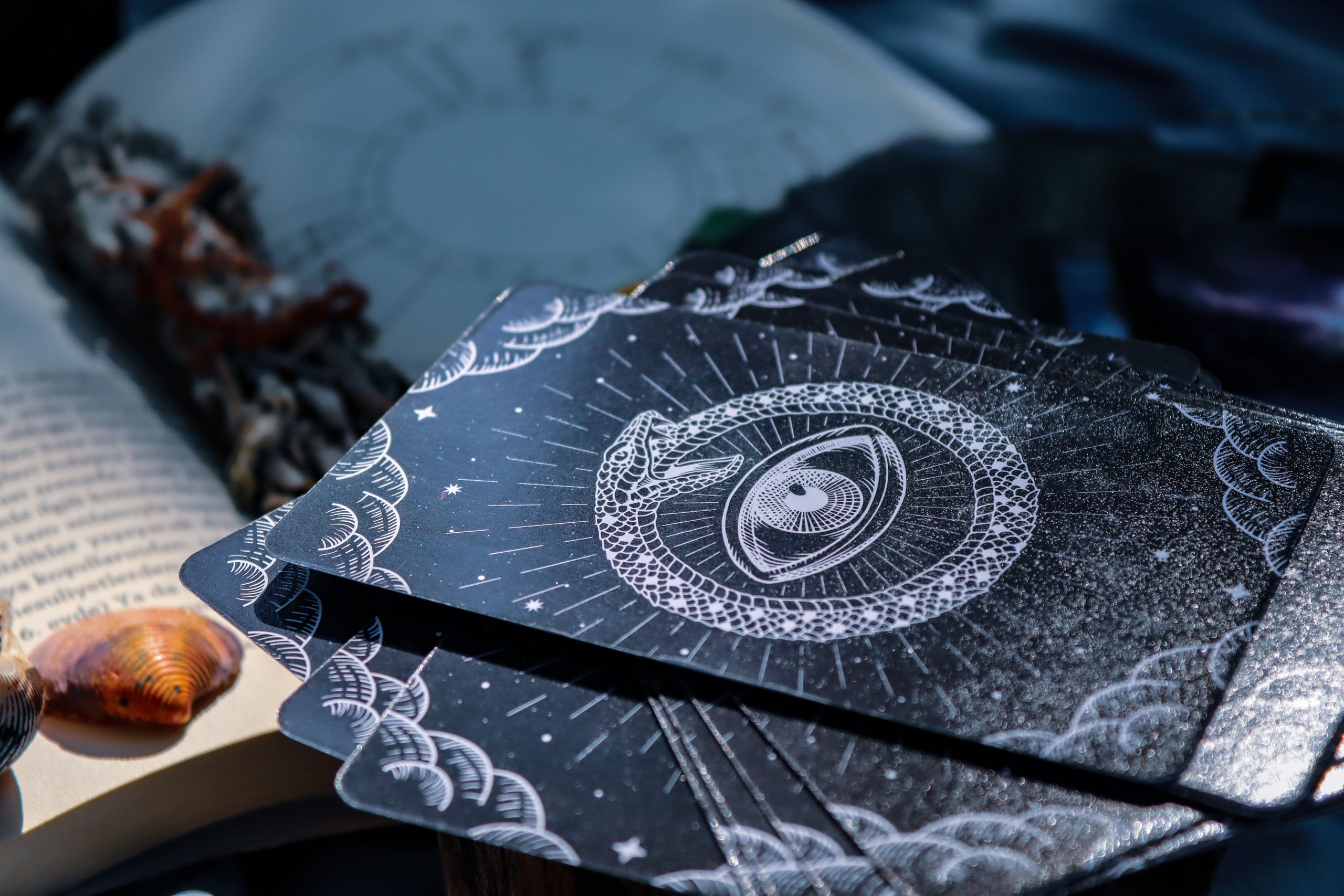 Cartes de tarot à côté d'un livre ouvert