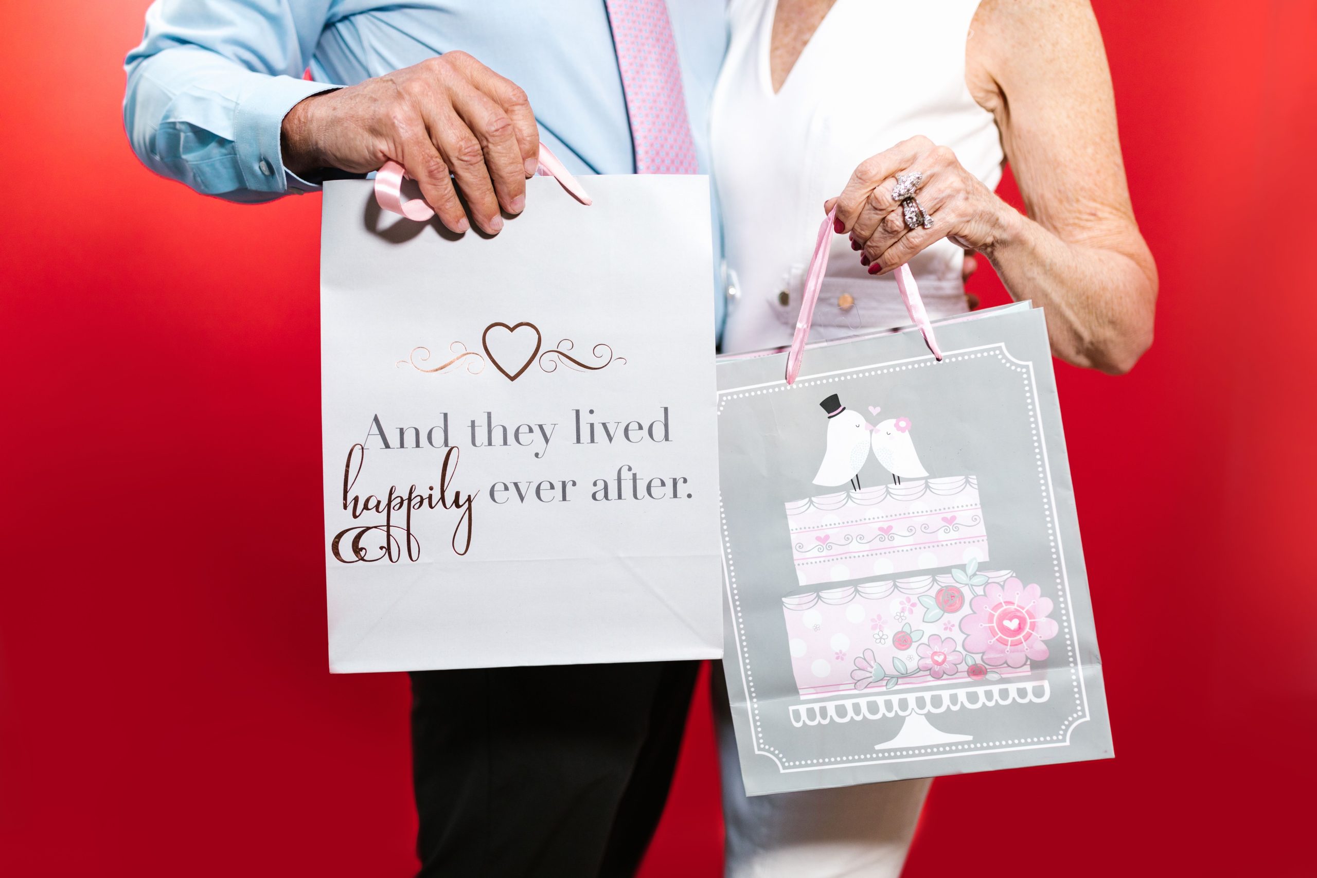 Couple senior échangeant des cadeaux sur fond rouge