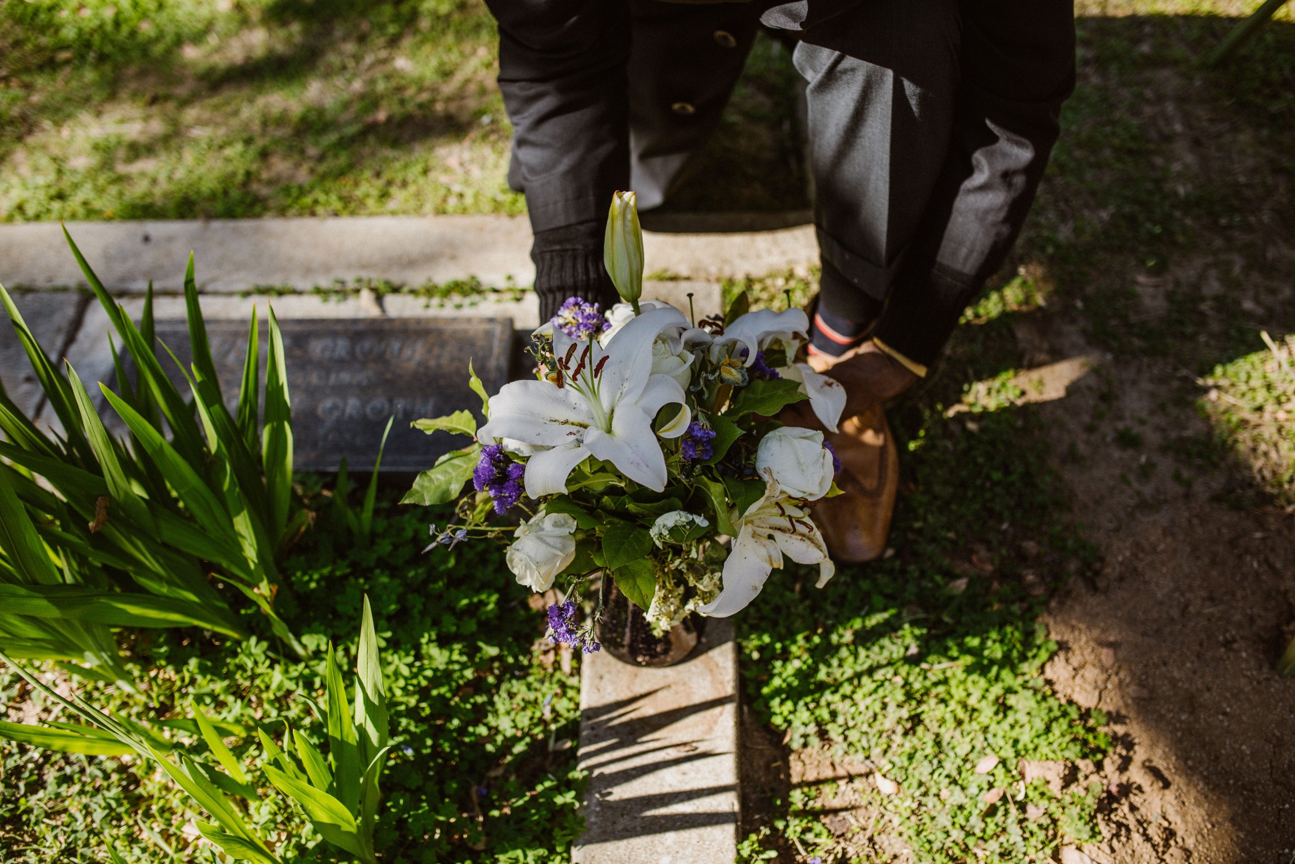 Homme déposant des fleurs sur une tombe