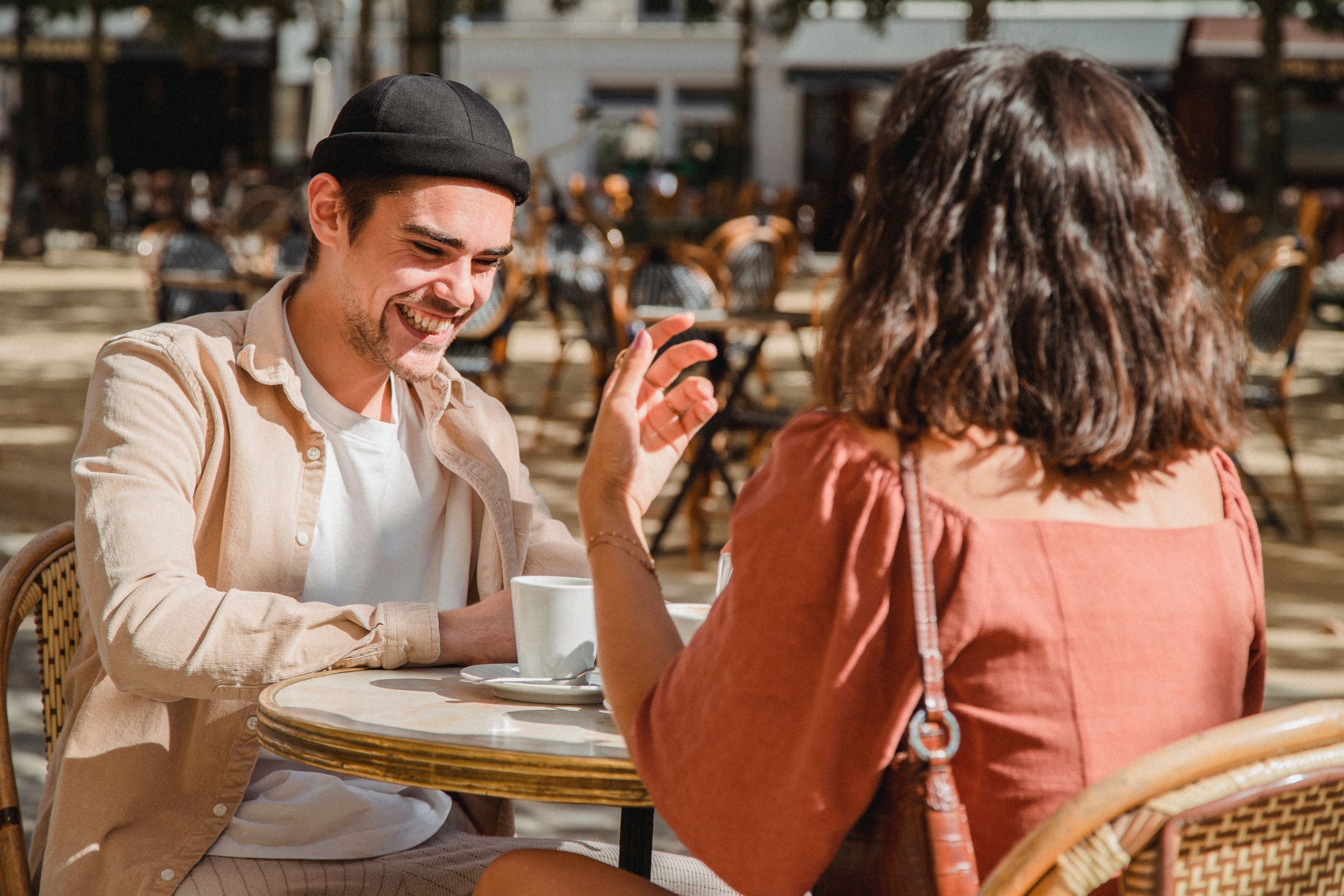 Couple heureux riant ensemble au cafe en plein air