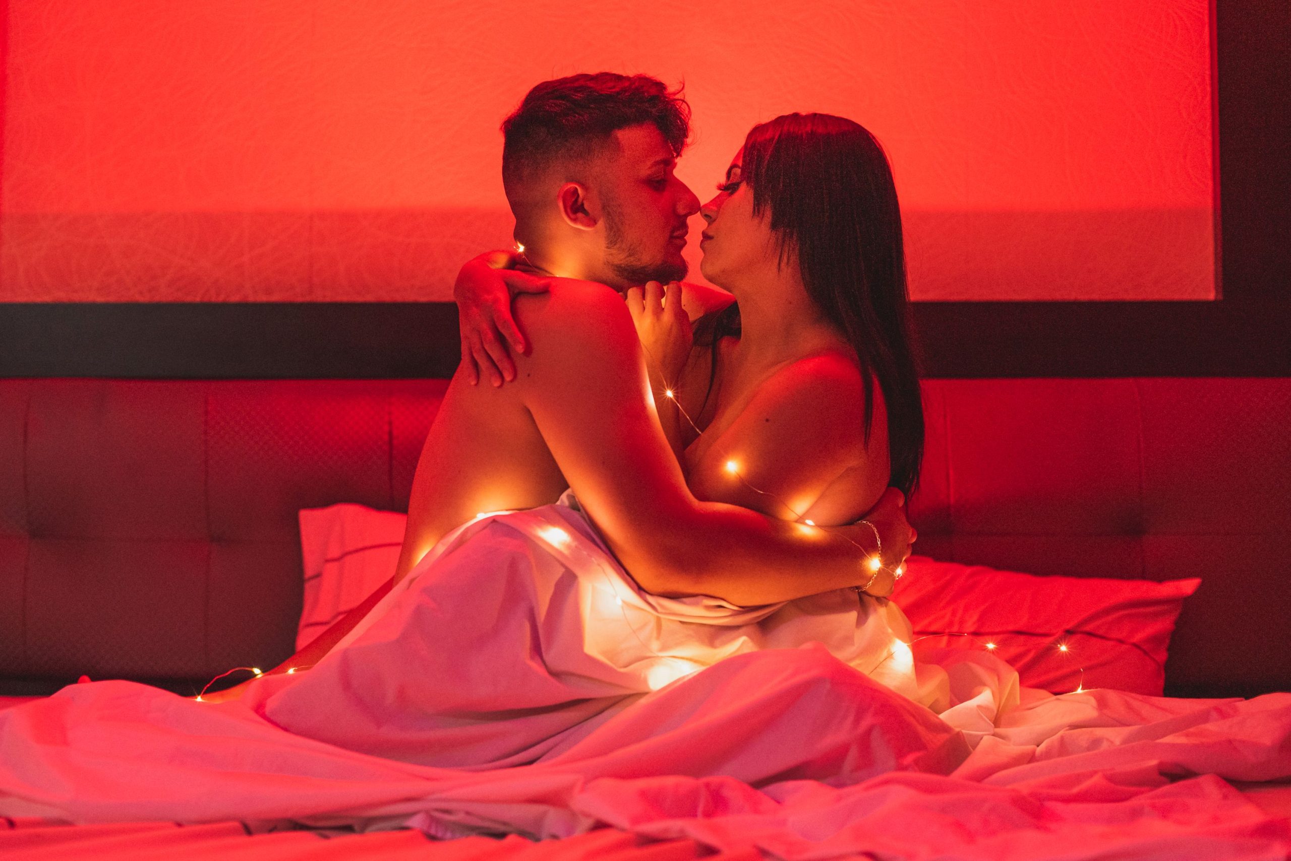 Couple passionné enlacé sous une lueur rouge douce et cosy