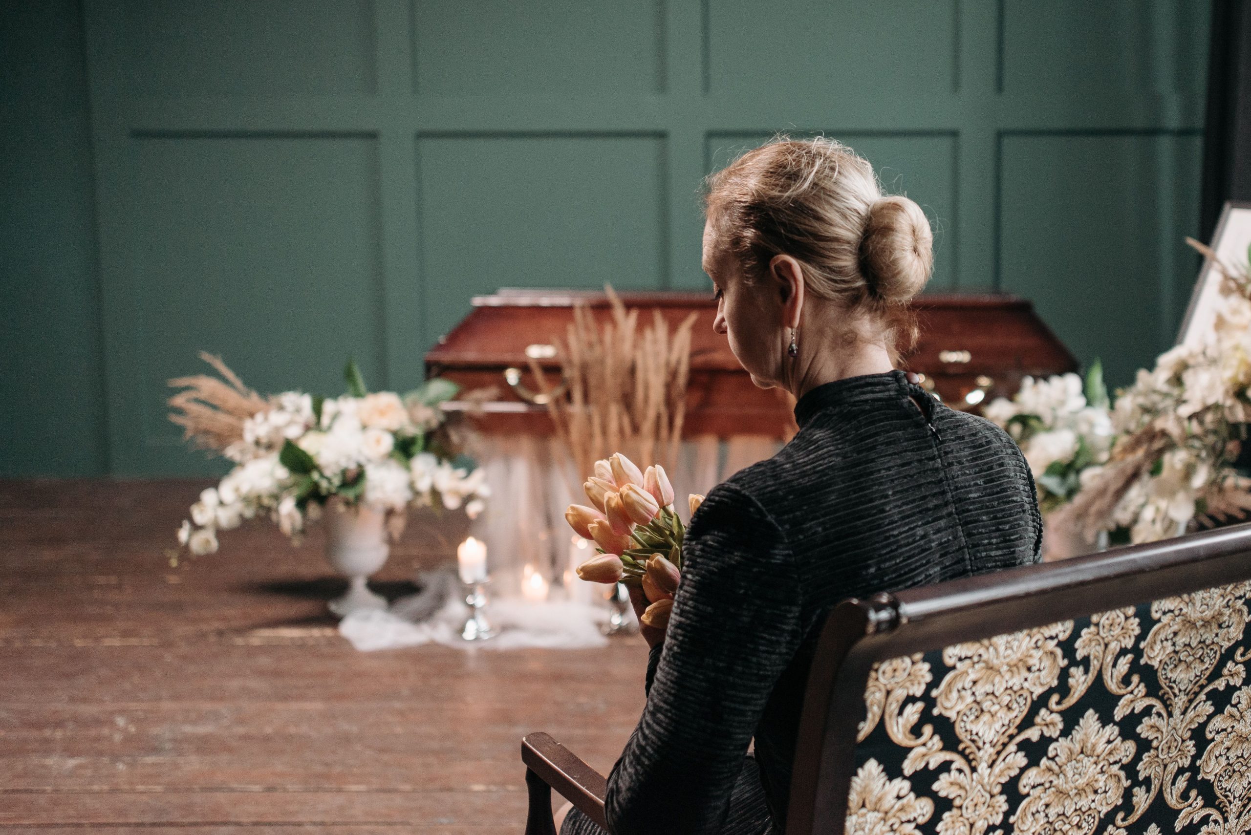 Femme en deuil tenant des fleurs funéraires