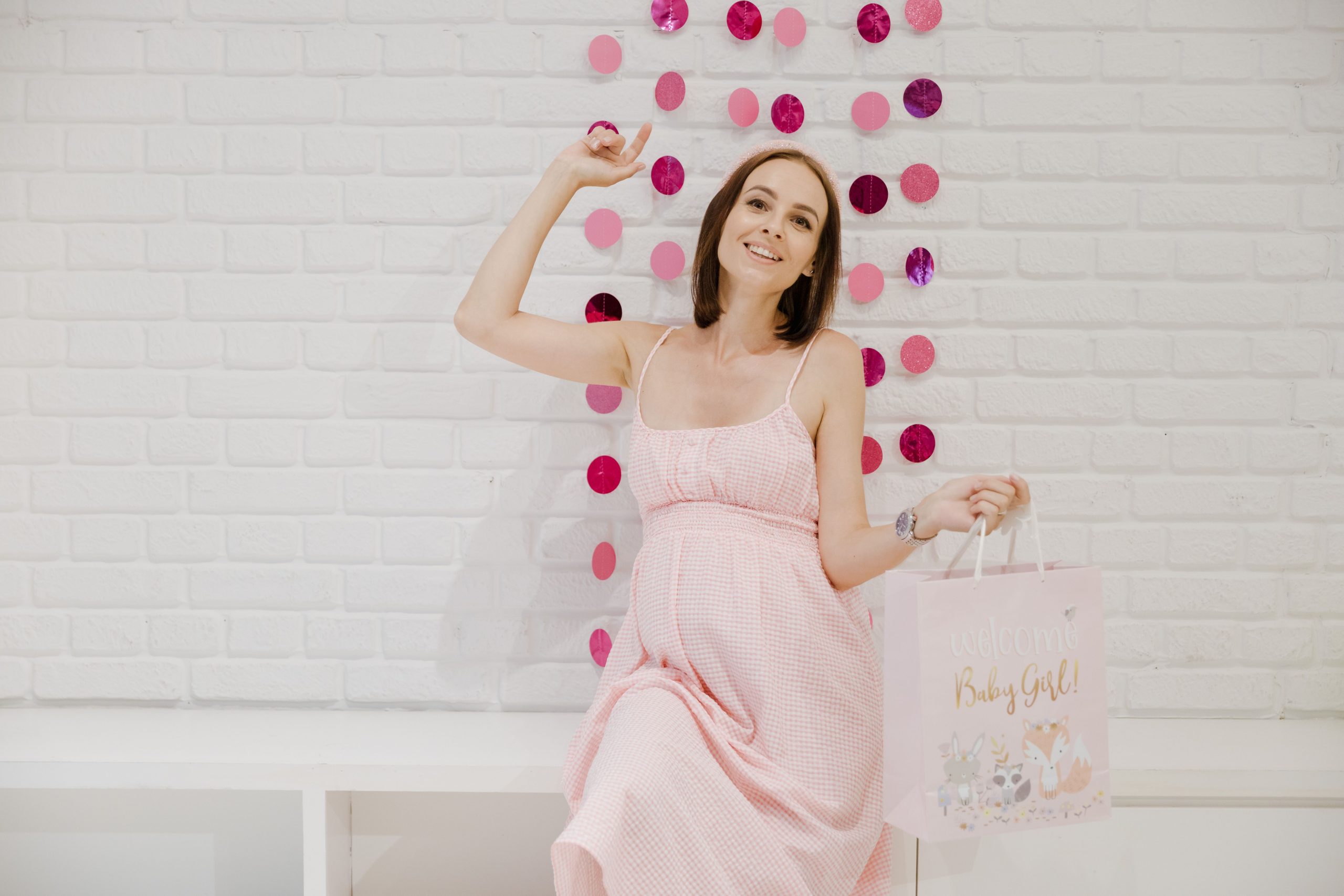 Femme enceinte souriante en rose à baby shower