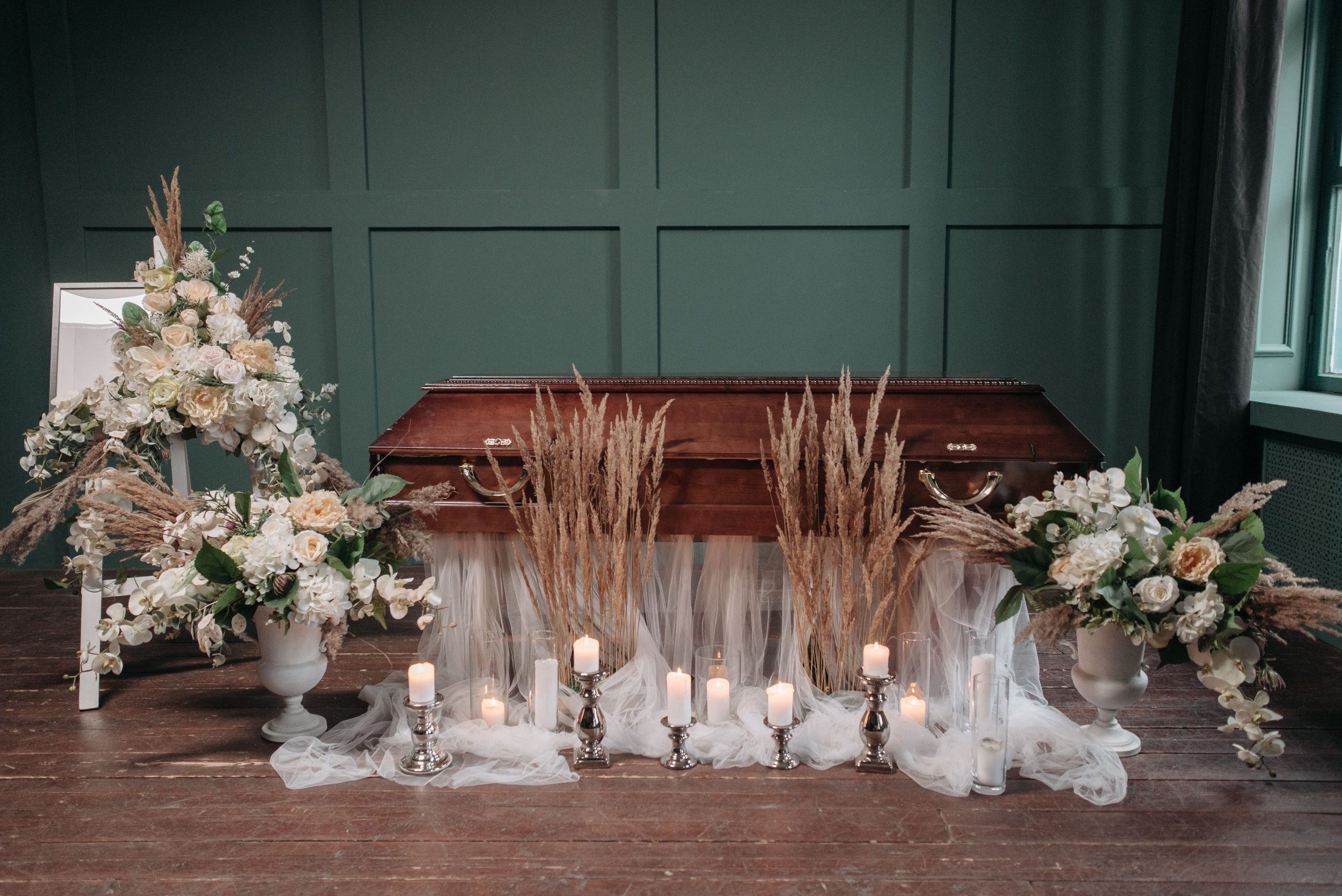 Cercueil en bois entouré de bougies et fleurs