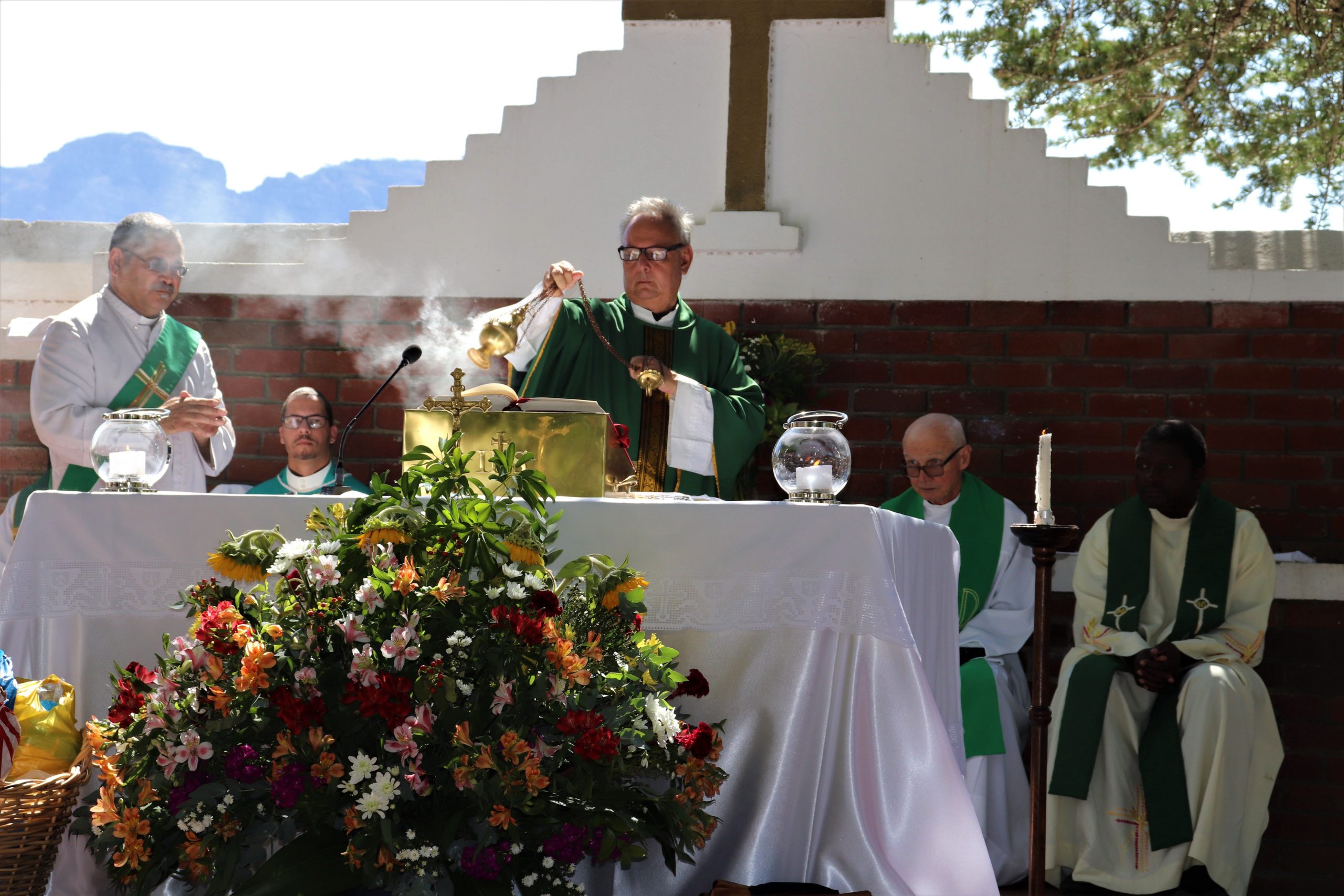 Prêtre officiant avec encensoir et Bible lors de la messe