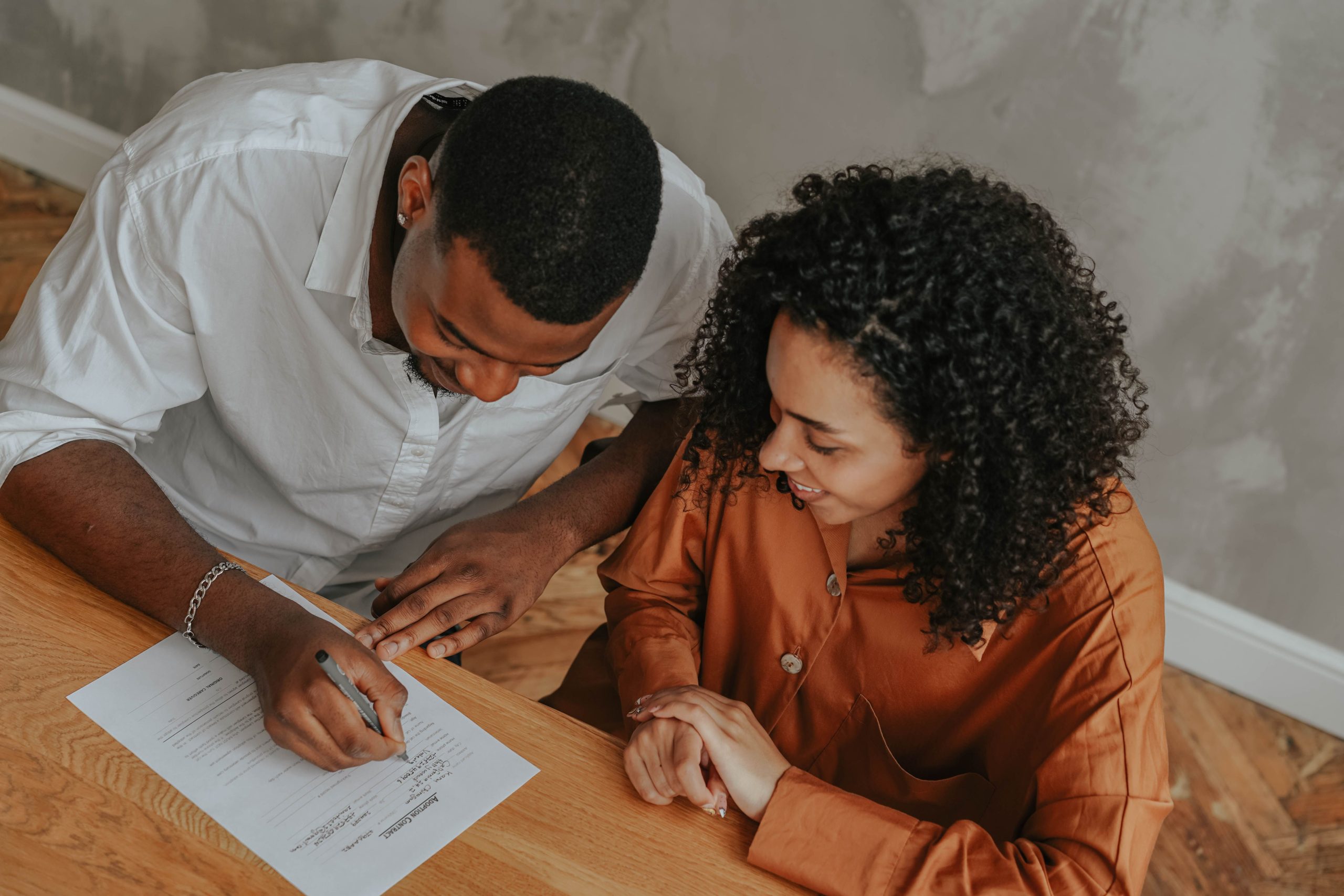 Couple signant certificat adoption vue dessus