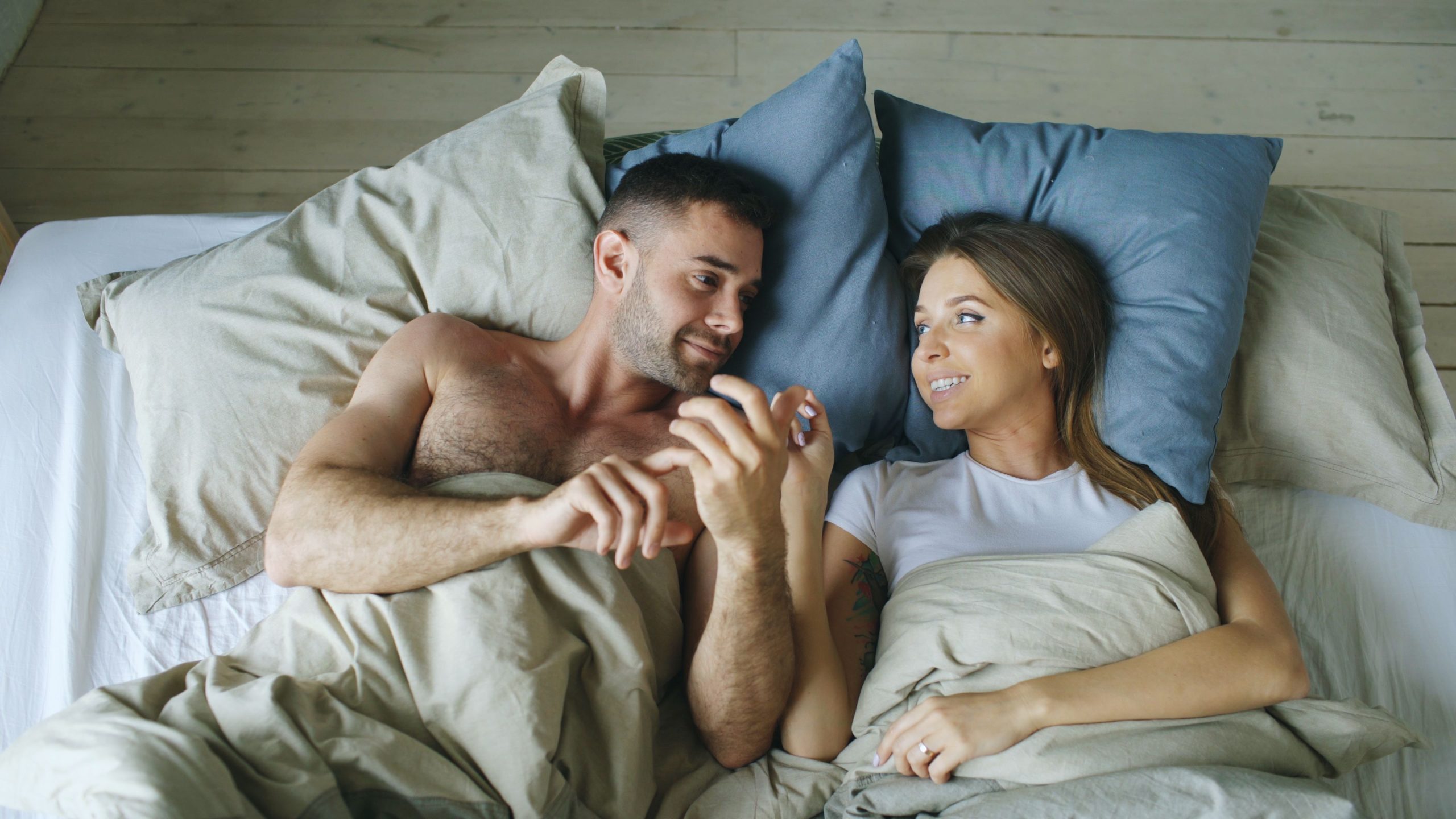 Couple au lit partageant une conversation matinale