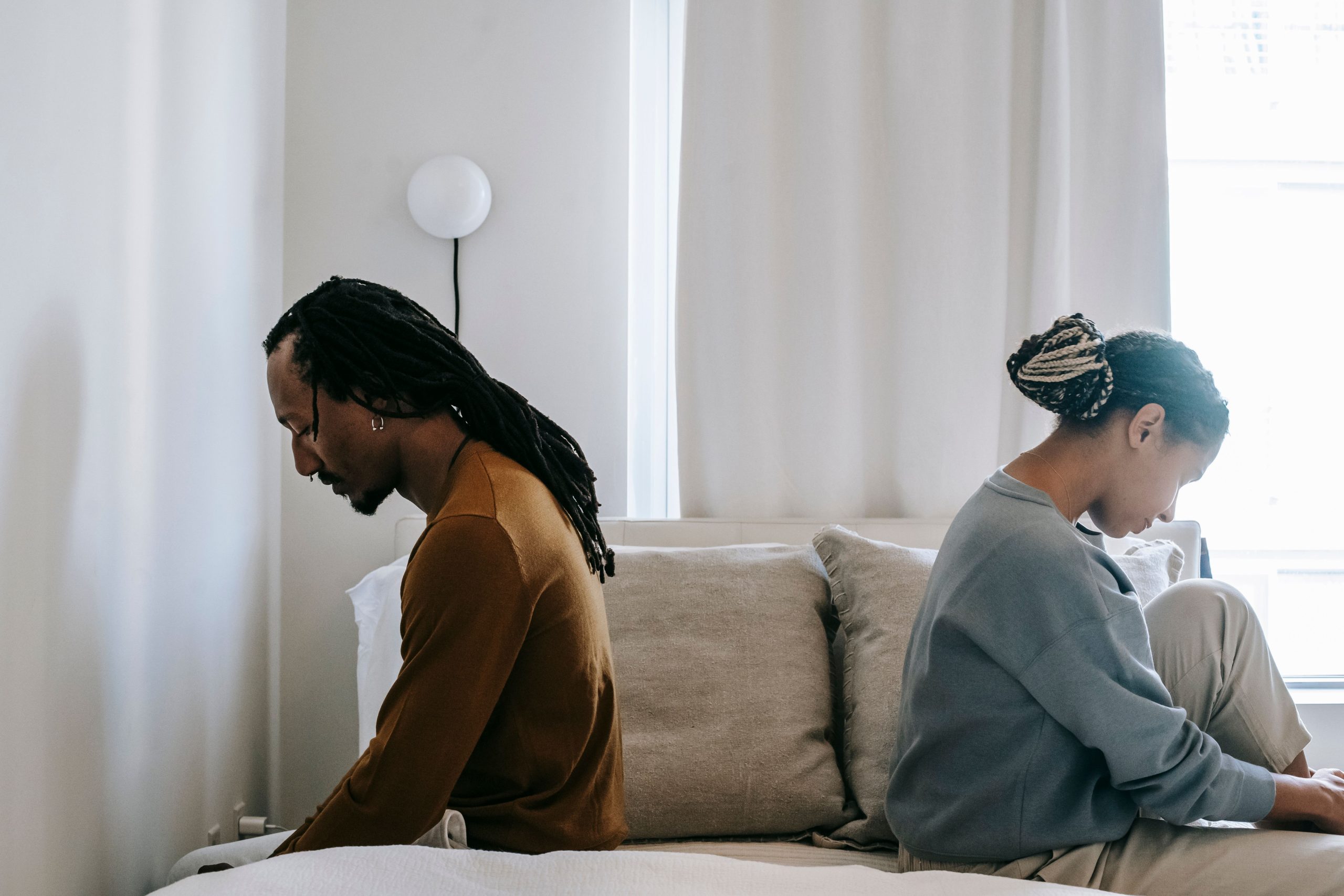 Couple africain triste assis dos à dos