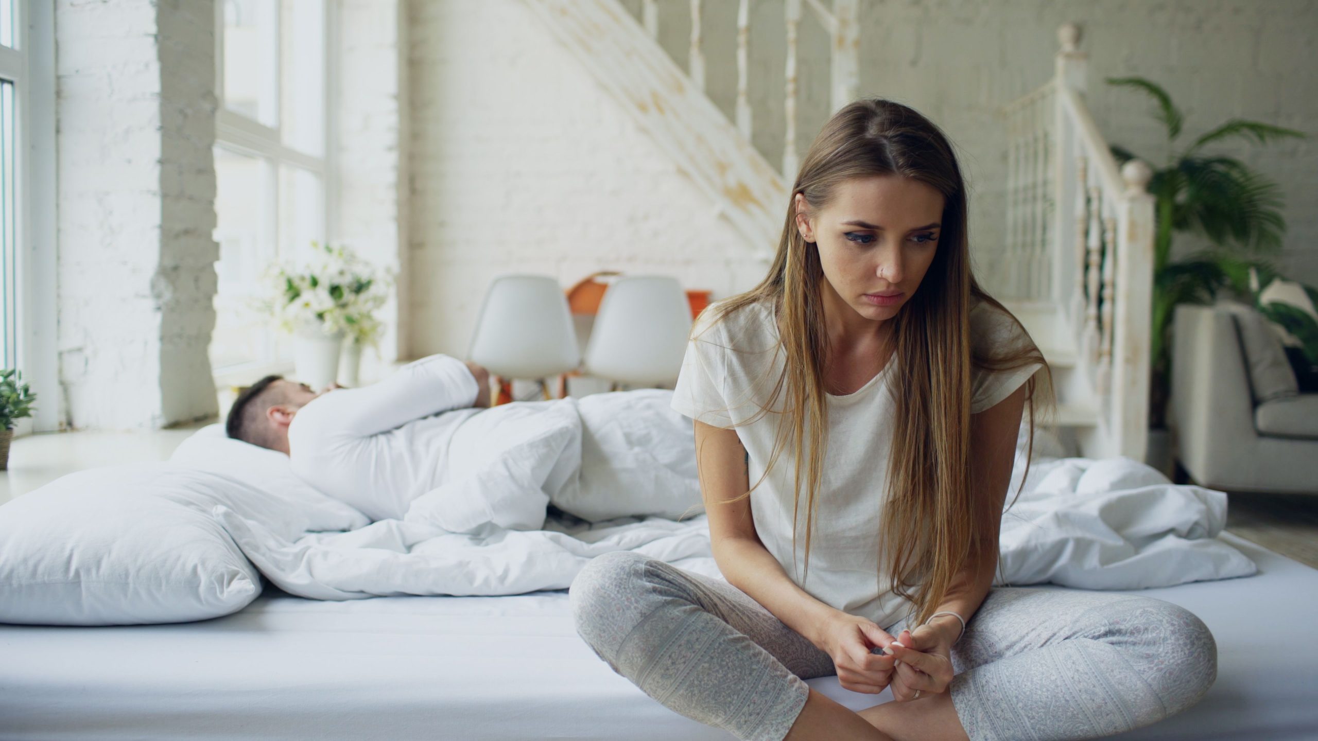 Femme songeuse sur le lit pendant sommeil