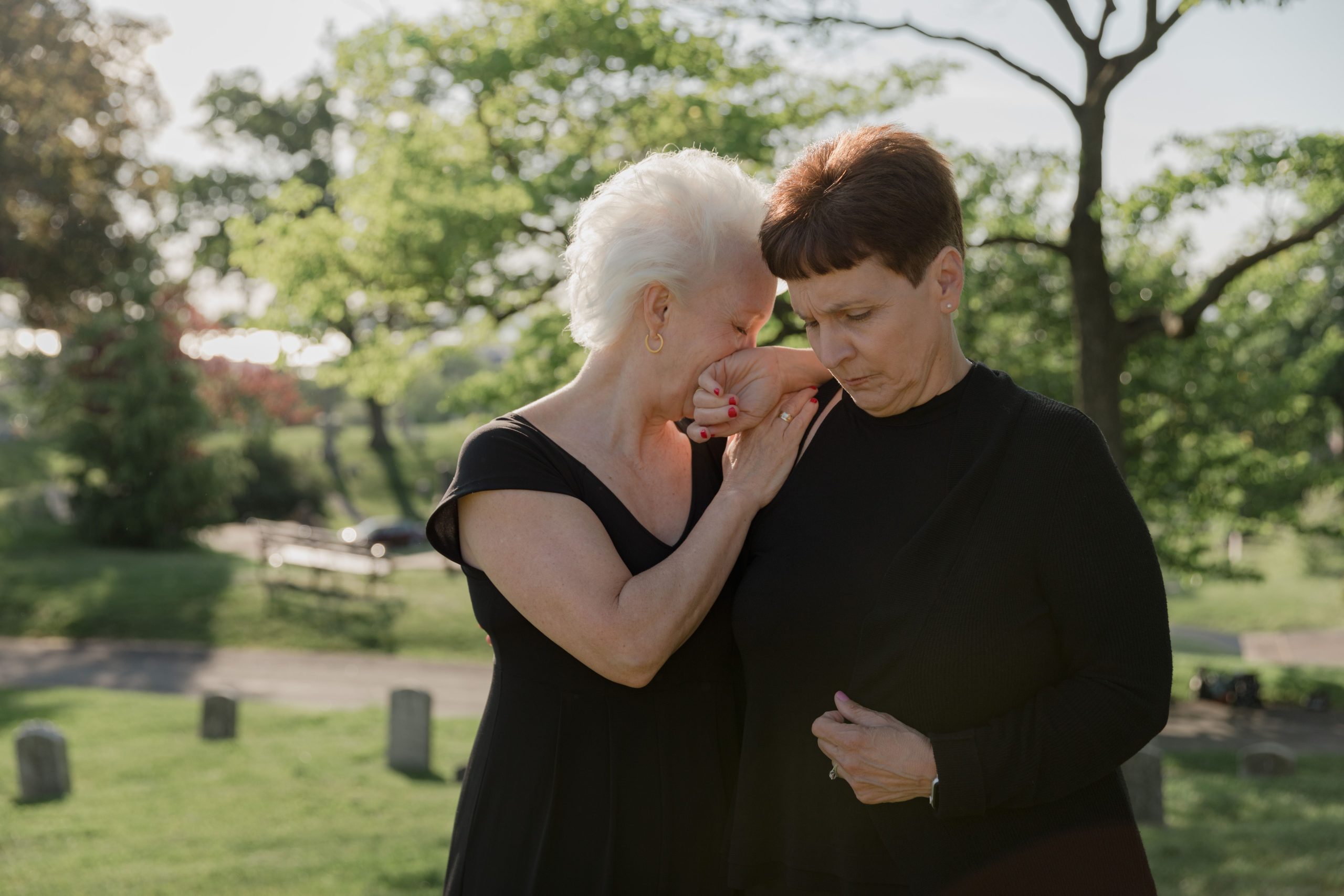 Deux femmes s'étreignant dans un cimetière en plein air.